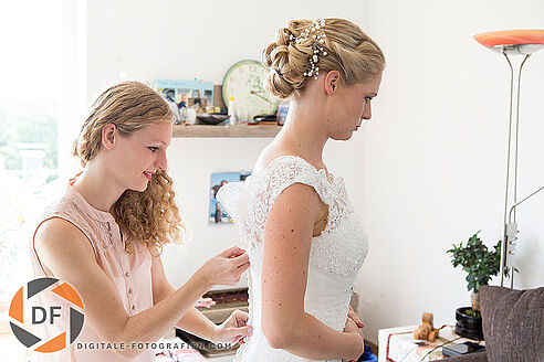 Die Braut bei den Hochzeitsvorbereitungen – ein intimer Moment, in dem die Braut für ihren großen Tag gestylt wird, eingefangen in einem stilvollen Foto.